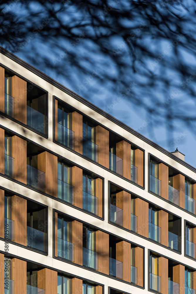 Detal na nowoczesny budynek wielorodzinny w centrum miasta. Duża ilość kondygnacji. Balkony i loggie. Słoneczna pogoda - obrazy, fototapety, plakaty 