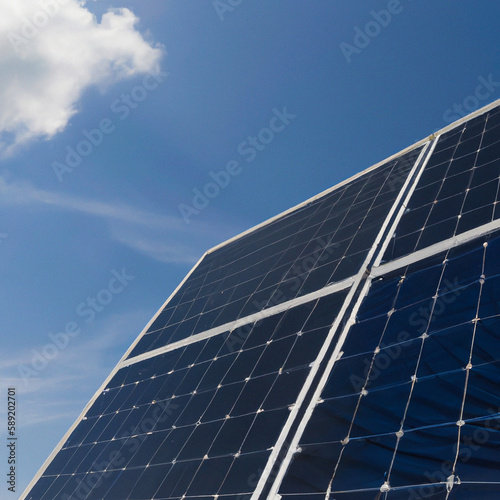 Blue solar panels against a blue sky with clouds. An image as a background for your creative design or illustrations. The image was created with Generative AI technology.