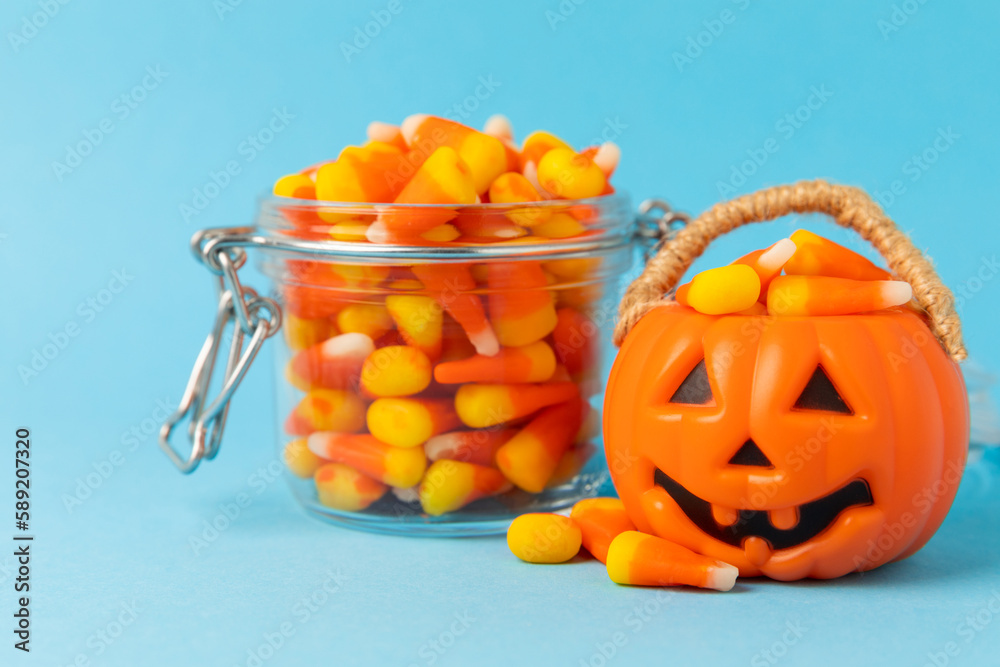 Halloween candy corn on blue texture background.Classic white, orange and yellow candy corn sweets for Halloween with.copy space.Halloween holiday concept with candy corn and jack o lantern.copy space Halloween candy corn on blue texture background.Classic white, orange and yellow candy corn sweets for Halloween with.copy space.Halloween holiday concept with candy corn and jack o lantern.copy space