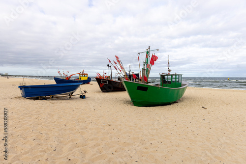Fototapeta Naklejka Na Ścianę i Meble -  Fishing boats by the sandy beach on the Baltic Sea on a sunny day, Wolin Island, Miedzyzdroje, Poland.