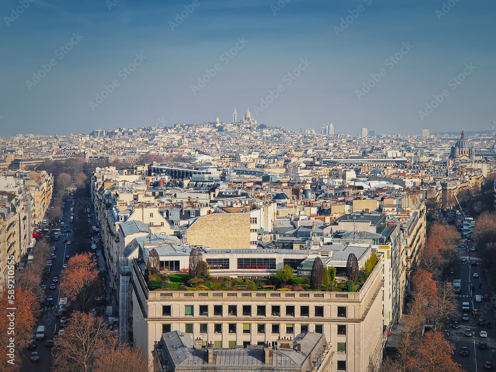 Aerial Paris cityscape with view to Sacre Coeur Basilica of the Sacred Heart, France. Beautiful parisian architecture with historic buildings, landmarks and busy city streets