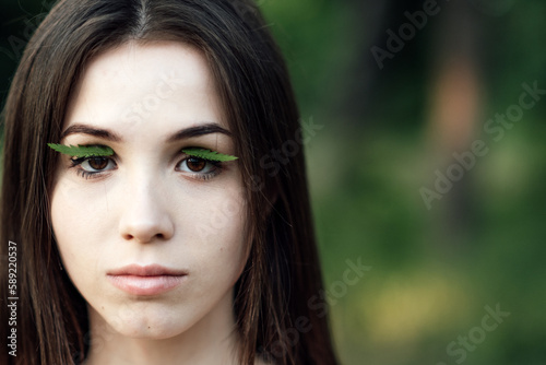 Celebrate Earth Month  Earth Day. Spend time in nature. Connect to nature is way to mitigate climate anxiety. Young woman  girl outdoors portrait on green nature background