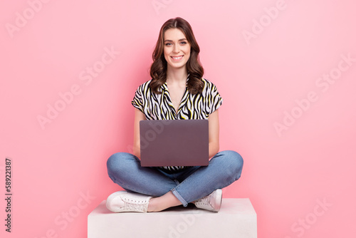 Full length photo of charming positive person sit podium use wireless netbook isolated on pink color background