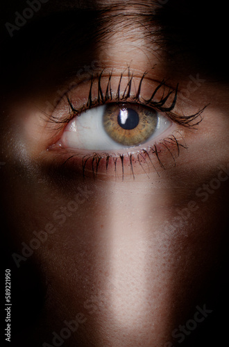 eye of the person looking through cross shaped hole photo