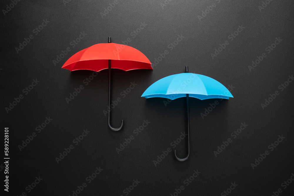 Red and blue umbrellas isolated on black background
