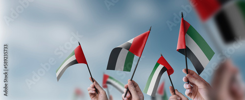Quadro su tela A group of people holding small flags of the Arab Emirates in their hands