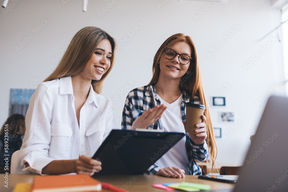 Content women working on project and drinking coffee in office Content women working on project and drinking coffee in office