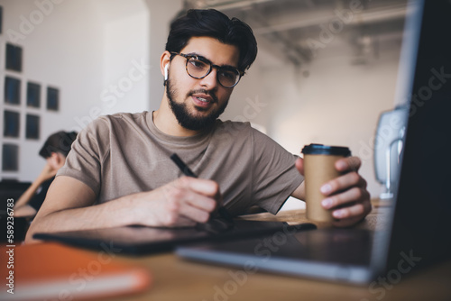 Focused man with coffee and laptop at workplace