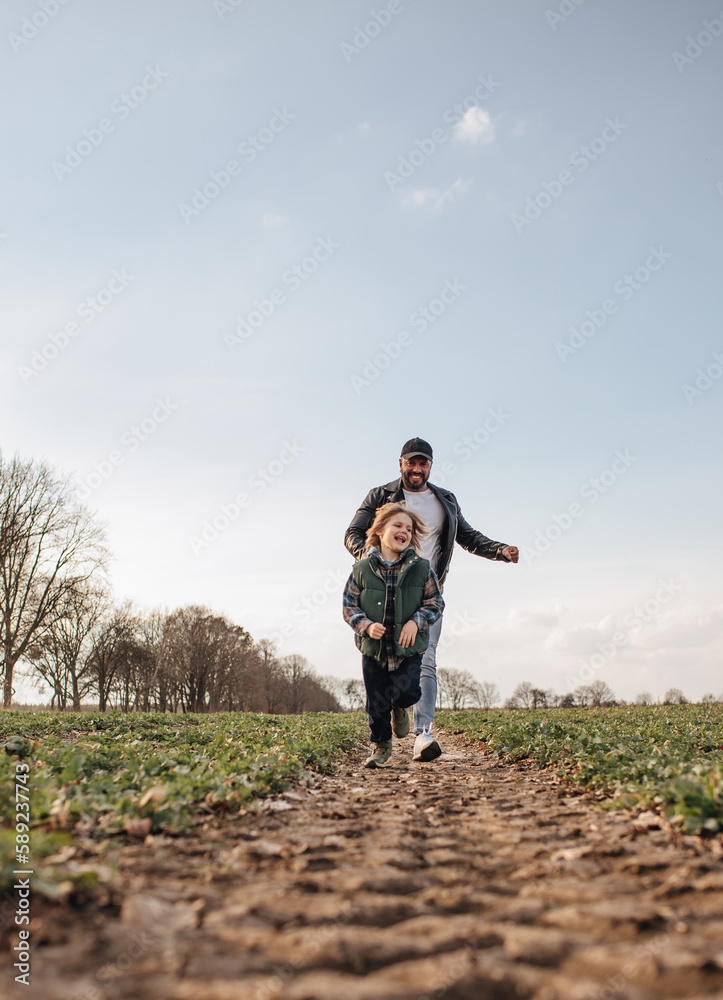 Fototapeta premium Father and son playing outdoors in spring