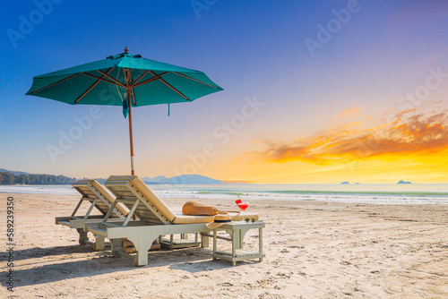 Fotografija Beaches and sun tables in Thailand,Row of empty sun loungers and orange parasols on the tropical beach at sunset