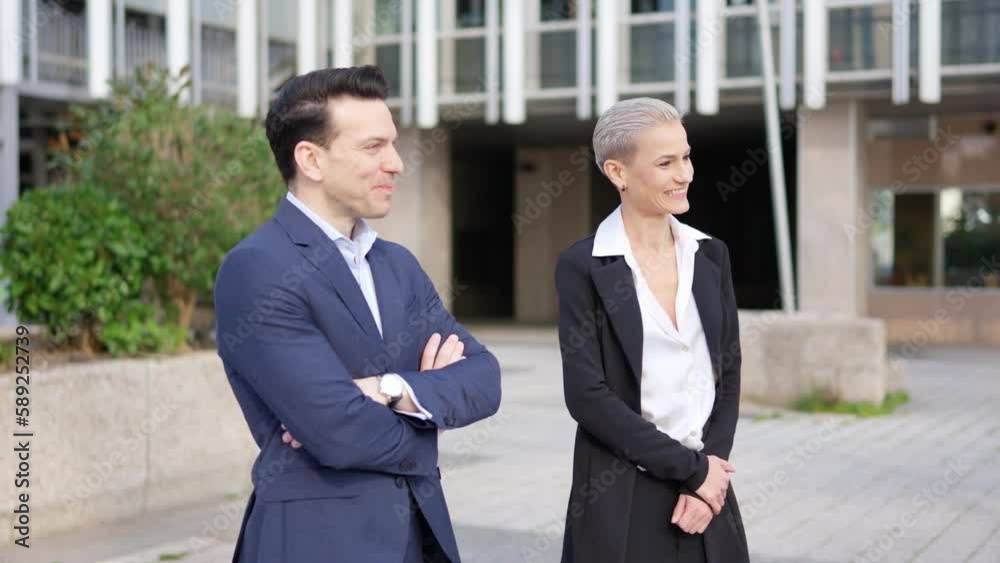 Business people talking and smiling in the city street
