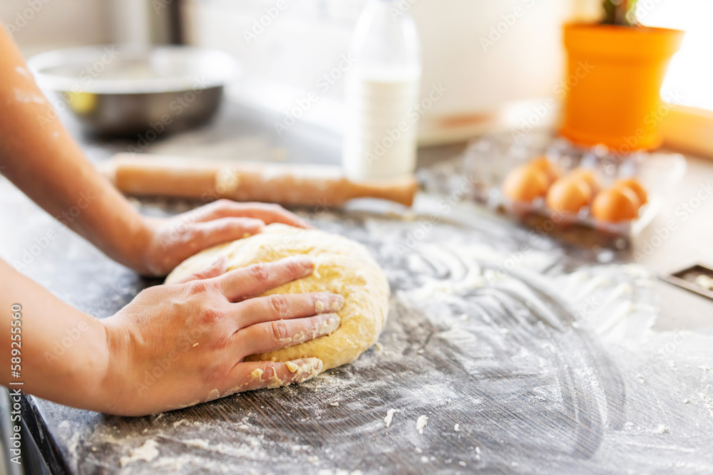 Womens hands kneading dough on table sprinkle with flour. Kneading dough Womens hands kneading dough on table sprinkle with flour. Kneading dough