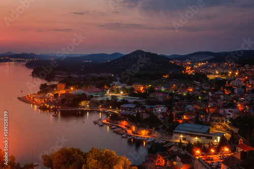 Top view of Sibenik from St Michael’s fortress wall at twilight, historic city on Adriatic coast in Dalmatia, Croatia, scenic cityscape with cozy houses and river Krka, outdoor travel background © larauhryn