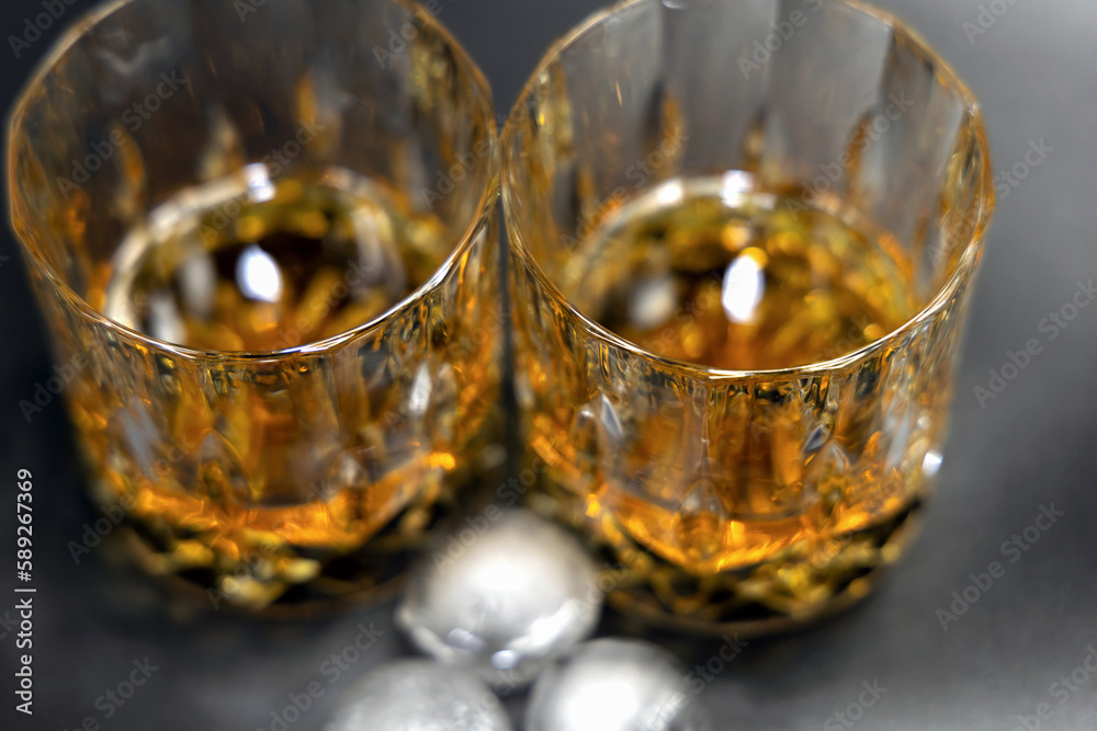 Two glasses of whiskey on a black background.High quality photo