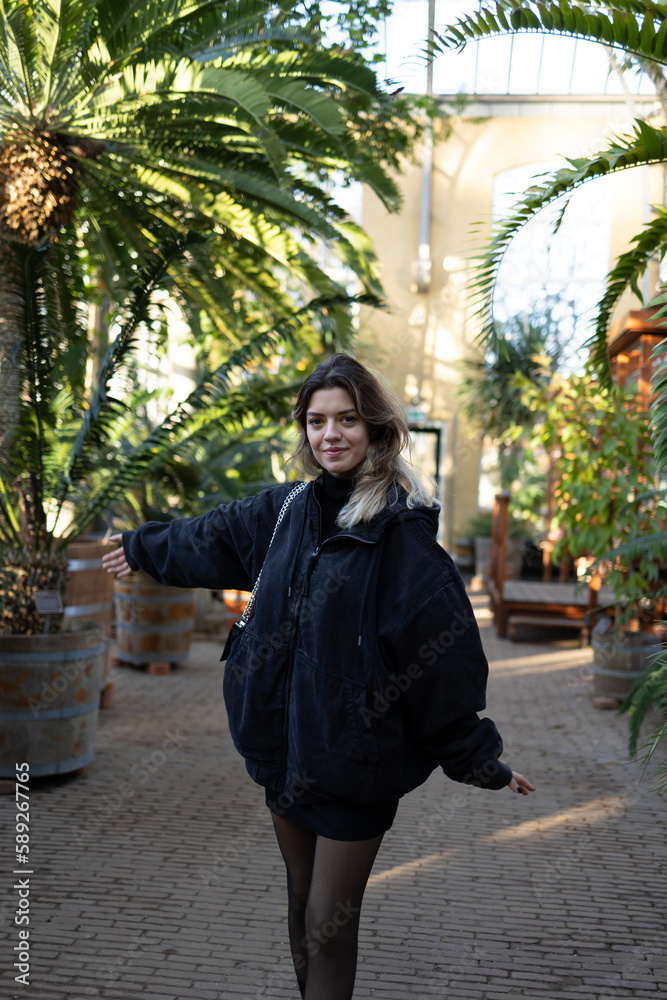 The botanic garden is an oasis of greenery, filled with a wide variety of plants and trees. A girl is wandering through the garden, taking in the beauty of her surroundings. The botanic garden is an oasis of greenery, filled with a wide variety of plants and trees. A girl is wandering through the garden, taking in the beauty of her surroundings.