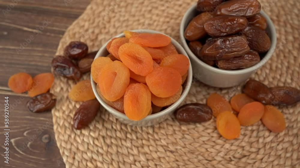 Dried apricots and dates fruits on dark wood background with copy space. BIO dried fruits. Dried apricots and dates fruits on dark wood background with copy space. BIO dried fruits.