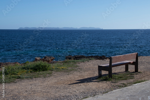 Bench for the rest of the walkers in front of the Mediterranean Sea  with the island of Cabrera in the background.