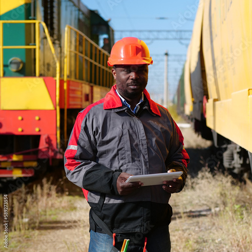 Photography African american railway man with tablet computer at freight train terminal