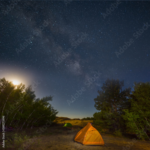 touristic camp under starry sky at moon rising, night outdoor travel background