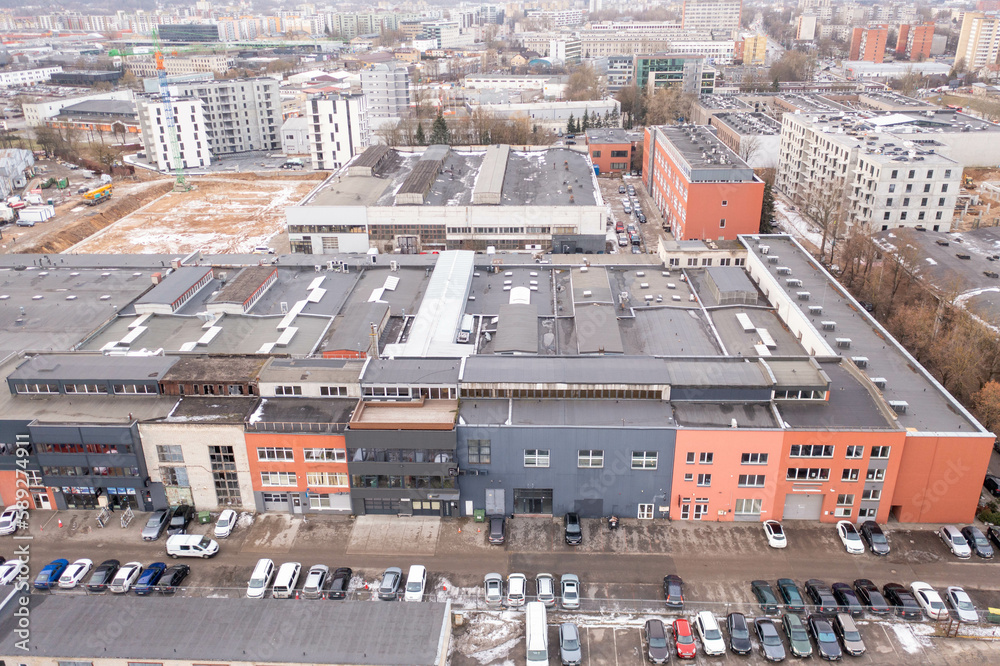 Drone photography of old warehouses reused as shops and office buildings and cityscape during spring cloudy morning .