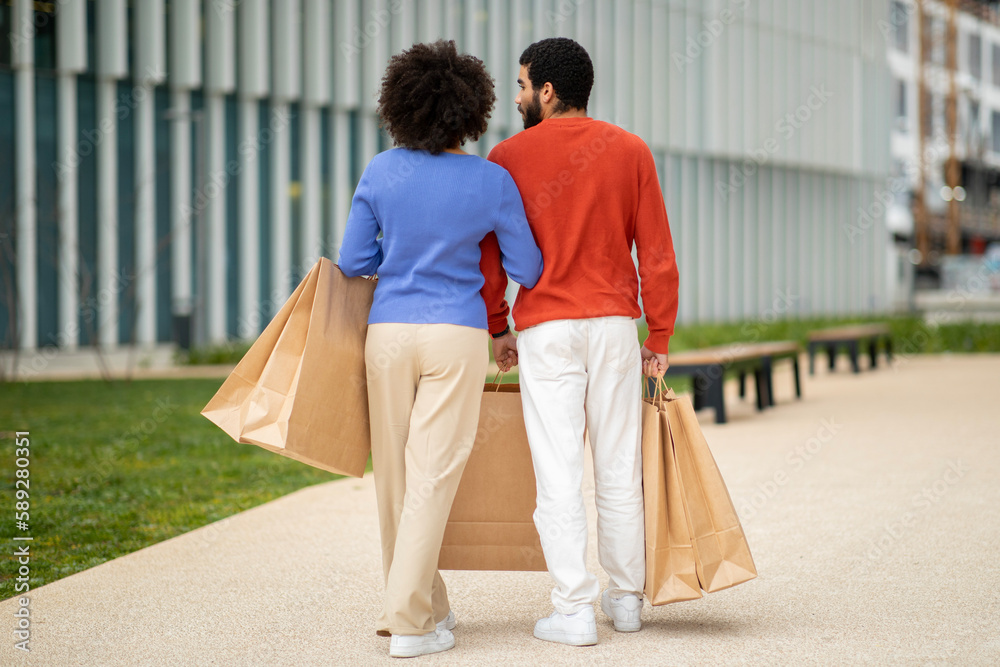 Back View Of Couple Walking Near Mall Outside On Weekend