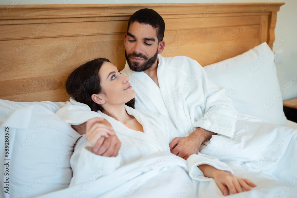 Fototapeta premium Diverse Couple In Love Embracing Lying In Bed Indoors