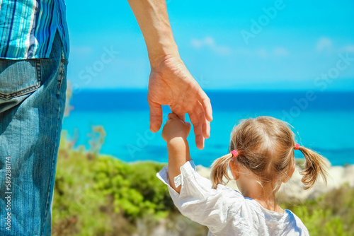 hands of happy parent and child at sea greece background