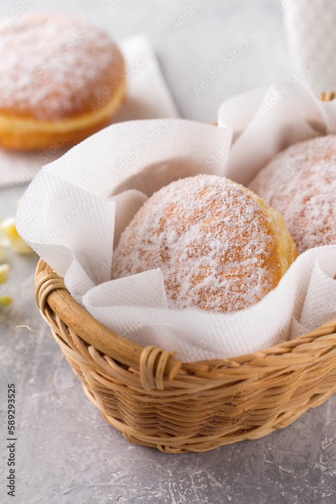 delicious donuts berliners with filling sprinkled with powdered sugar in basket on a grey background delicious donuts berliners with filling sprinkled with powdered sugar in basket on a grey background