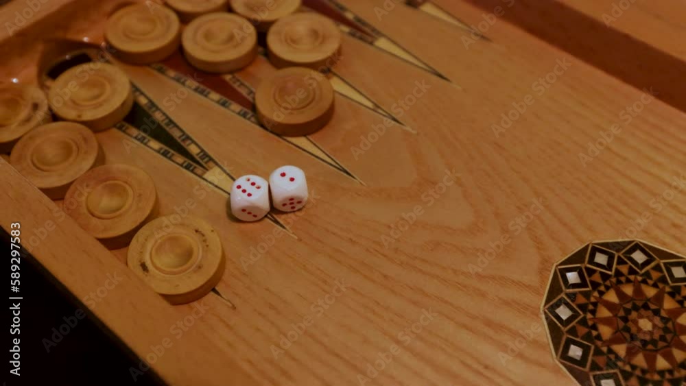 Backgammon Game Dice Rolling - Close-Up Shots of Two Dice Tumbling and Landing on the Board with Intense Focus on Game Action and Chance. Backgammon Game Dice Rolling - Close-Up Shots of Two Dice Tumbling and Landing on the Board with Intense Focus on Game Action and Chance.