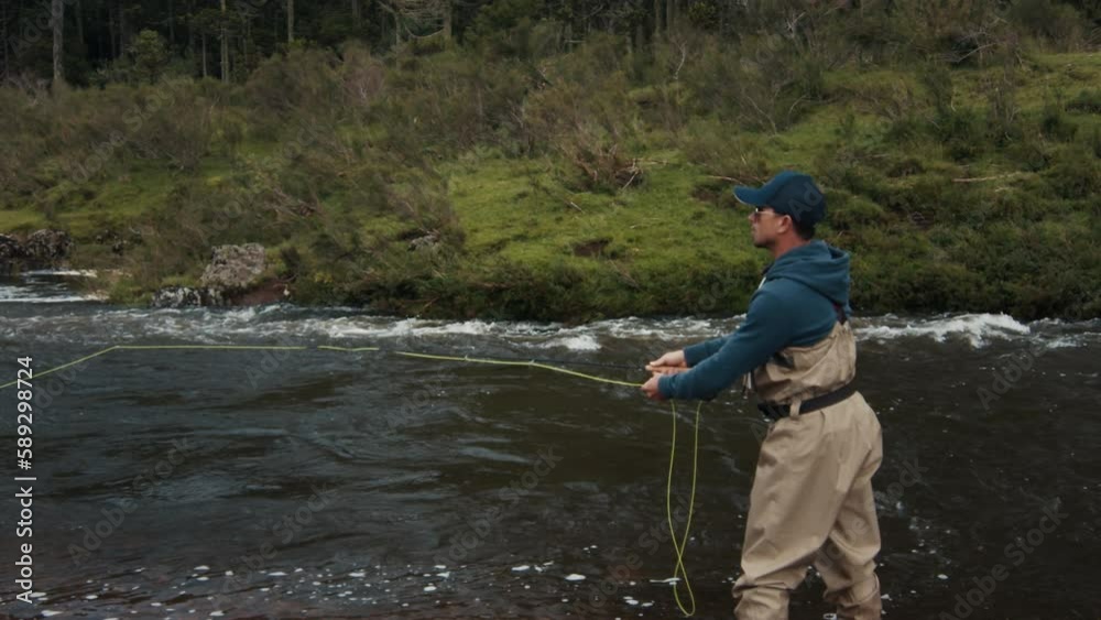 Fly fishing. Fisherman in waders casts the line and fishing on the river Fly fishing. Fisherman in waders casts the line and fishing on the river
