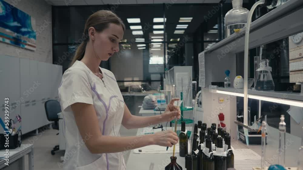 Winery Specialist Uses Wine Pipette For Alcohol Product Quality Test. Testing Quality Of Alcoholic Drink Product In Laboratory. Flasks. Product Quality Test Of Alcoholic Beverage By Expert. Sampling Winery Specialist Uses Wine Pipette For Alcohol Product Quality Test. Testing Quality Of Alcoholic Drink Product In Laboratory. Flasks. Product Quality Test Of Alcoholic Beverage By Expert. Sampling