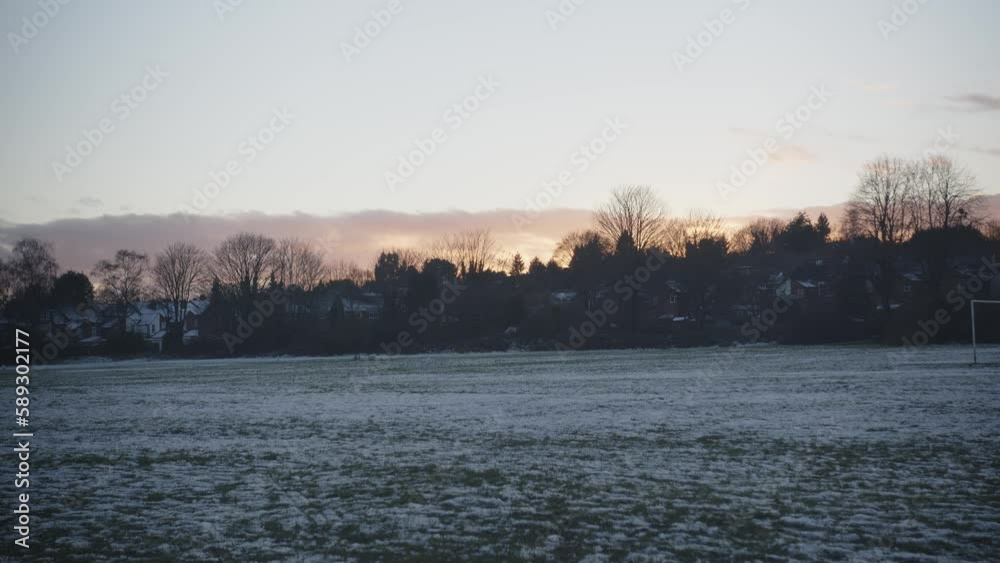 Houses across a common come into focus with a winters sunset Houses across a common come into focus with a winters sunset