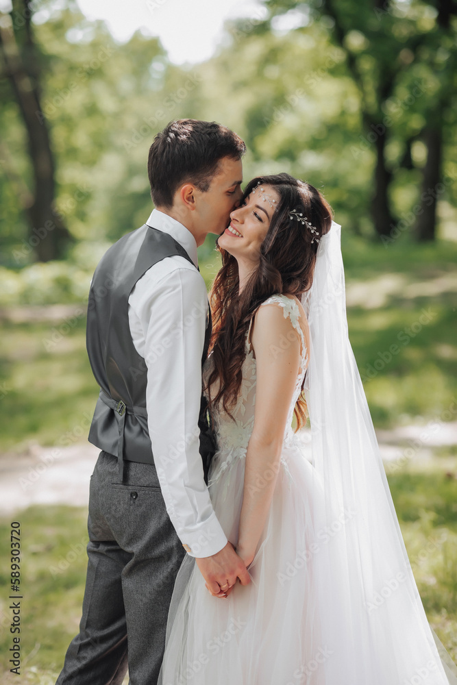 Stylish young brides, happy on their day, enjoy each other. Holding hands in a spring park. Portrait. Spring wedding. Natural makeup