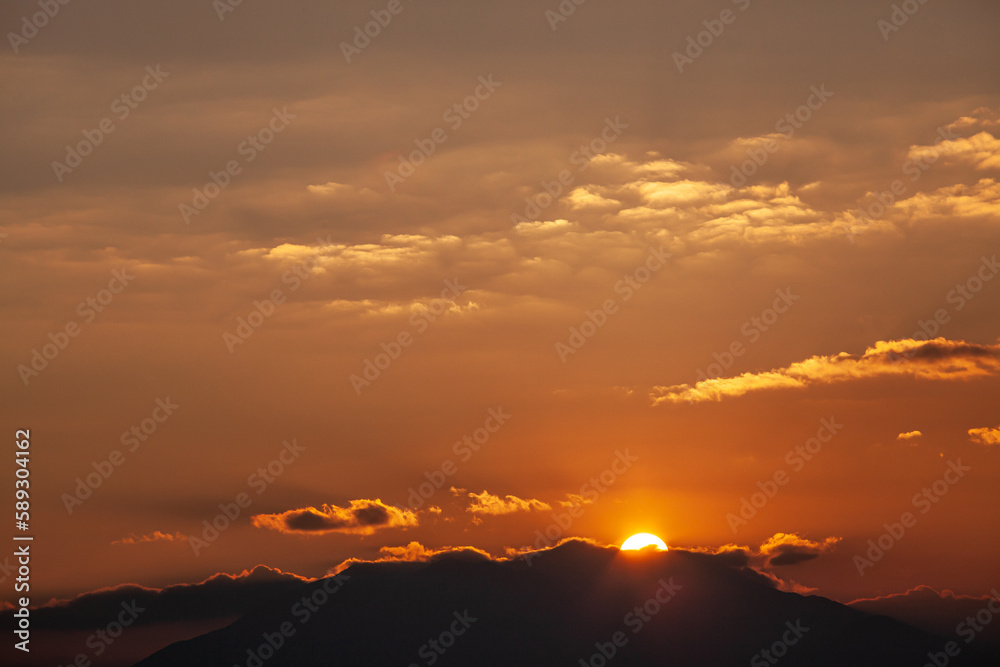 sunset in the mountains with golden sky, clouds golden hour, sun, sun rays