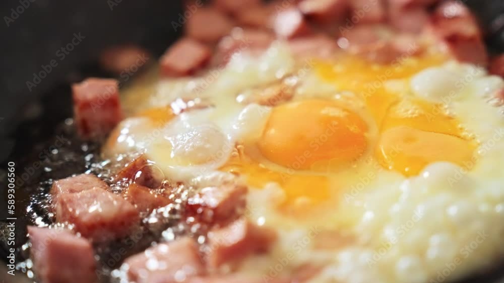 Fried eggs with sausage in a frying pan. healthy hearty breakfast concept. Fried eggs with sausage for breakfast. Pieces of sausage and scrambled eggs in a frying pan are fried in bubbles food of oil Fried eggs with sausage in a frying pan. healthy hearty breakfast concept. Fried eggs with sausage for breakfast. Pieces of sausage and scrambled eggs in a frying pan are fried in bubbles food of oil