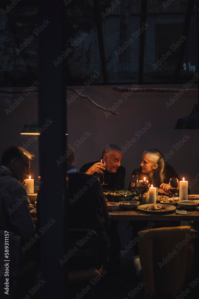 Man and woman talking to each other during dinner party at night Man and woman talking to each other during dinner party at night