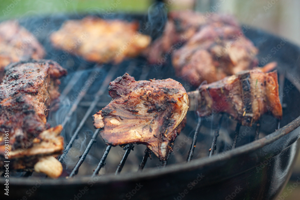 Cooking different meat on barbecue. Grilled and roasted lamb steaks on bbq Cooking different meat on barbecue. Grilled and roasted lamb steaks on bbq