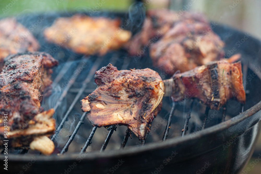 Cooking different meat on barbecue. Grilled and roasted lamb steaks on bbq