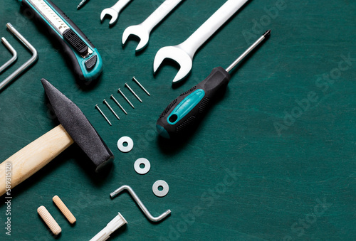 Set of professional tools for renovation or home repairs on the green wooden background. Copy space