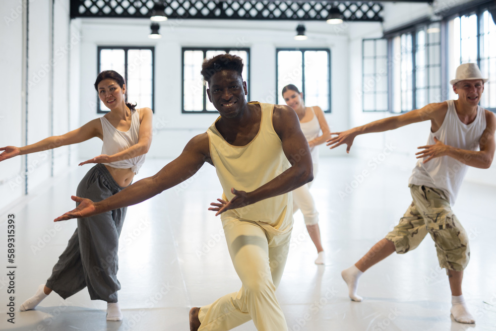 Four dancers exercising modern dance movements in large ball room Stock ...