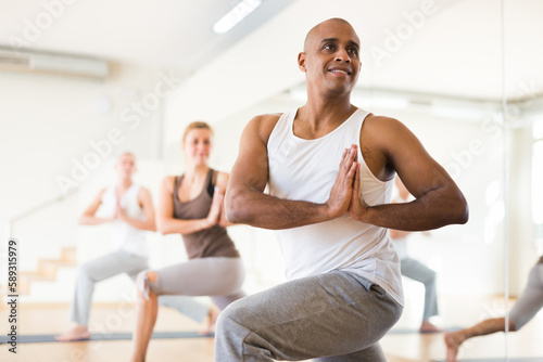 Scene of a group of people practicing couples yoga in class