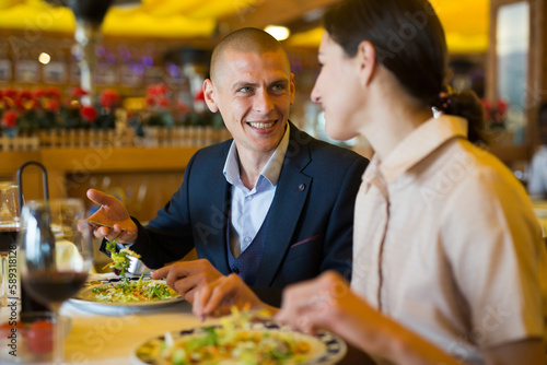 Cheerful man and woman enjoying evening meal in restaurant  having date