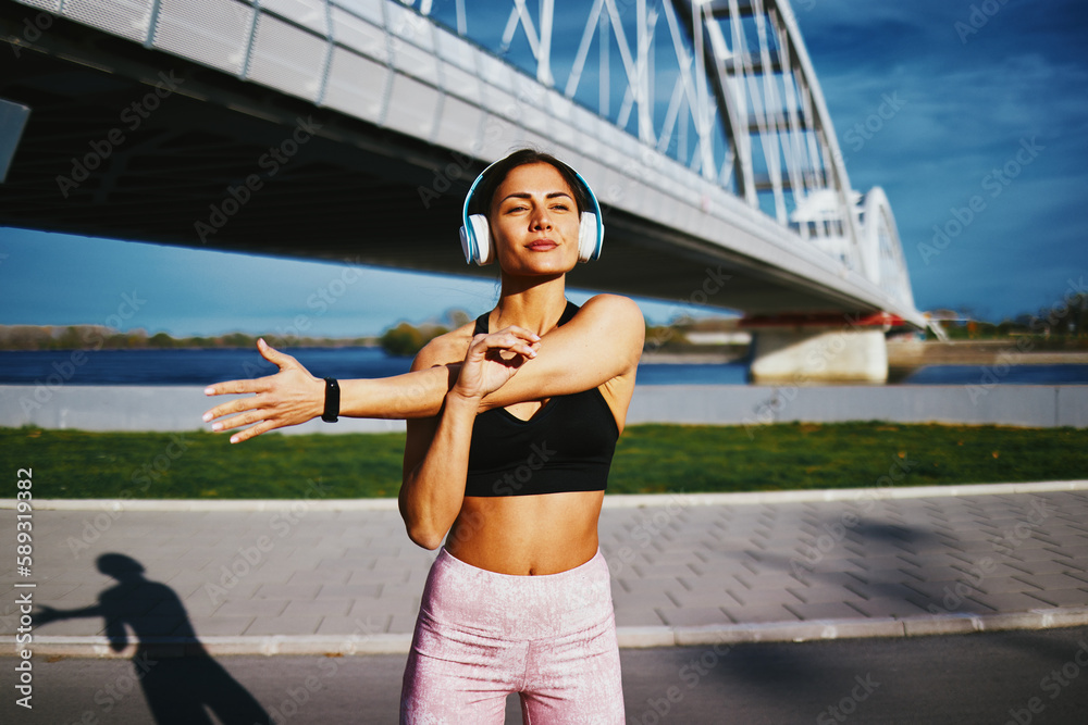 Young woman doing stretching before jogging outdoor