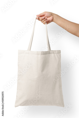 Female hand holding a blank tote canvas bag mockup isolated on a transparent background, PNG. High resolution.