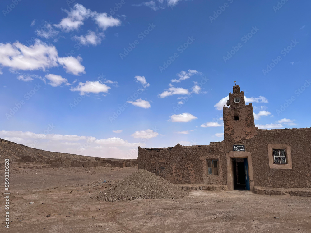Merzouga, Morocco, Africa: panoramic road in the Sahara desert, with view of the opened mosque of an ancient and abandoned nomadic village, near the fossil mines in the Black Mountain area