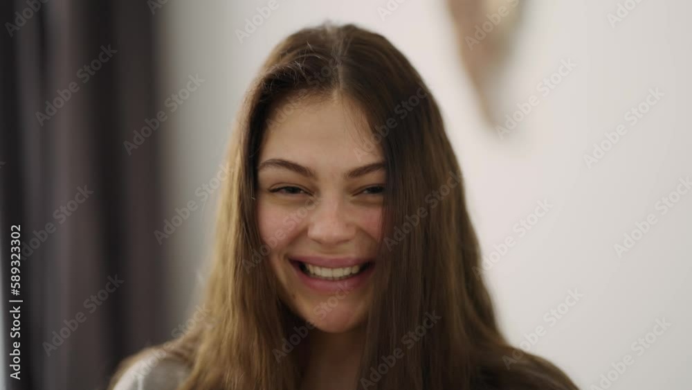 Long haired smiling woman looking at camera standing at home Long haired smiling woman looking at camera standing at home