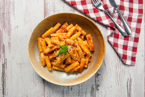 Photos Top view of rigatoni pasta  on ceramic plate with arrabiata sauce on a white woo
