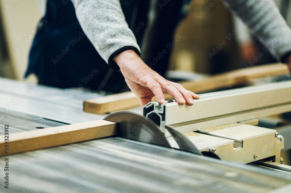 Close up of a craftsman cutting material on a saw. Close up of a craftsman cutting material on a saw.