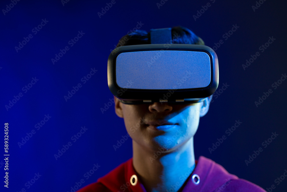Portrait of asian man using vr headset in studio with blue light with copy space Portrait of asian man using vr headset in studio with blue light with copy space