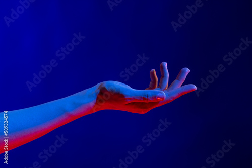 Exposed hand in studio with blue light with copy space